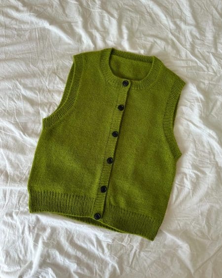 Maggie Vest fra PetiteKnit der ligger på et hvidt lagen.
