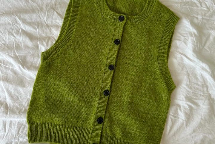 Maggie Vest fra PetiteKnit der ligger på et hvidt lagen.