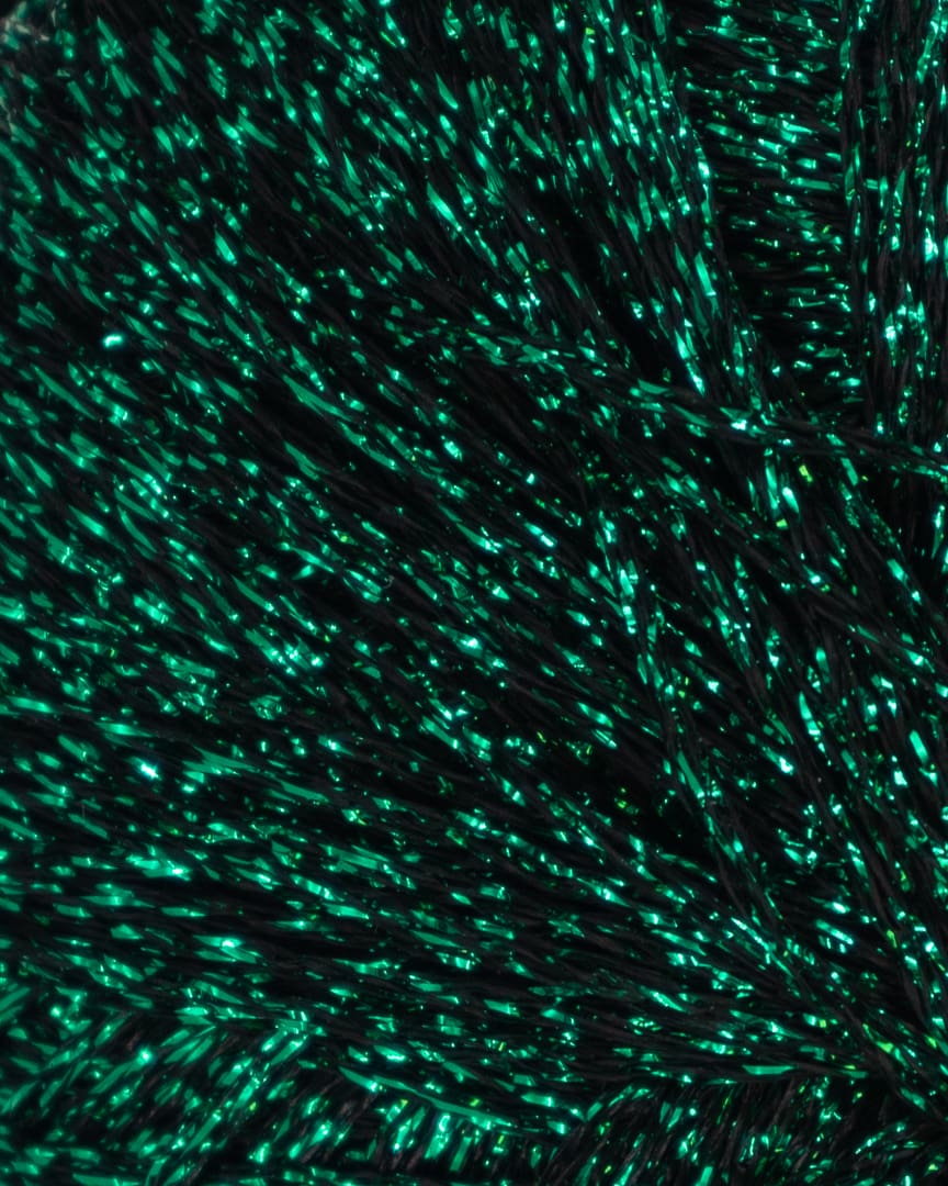 Paia Glimmergarn i fv. 712 Emerald Shimmer, der er en mørkegrøn og sort kombination.