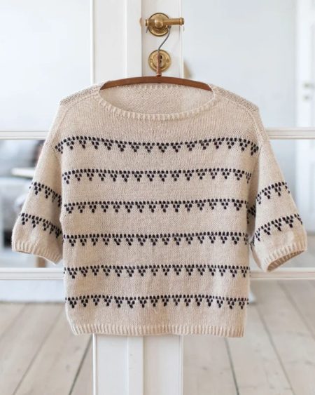 Sandfarvet Grape Tee fra Anne Ventzel, der hænger på en bøjle.