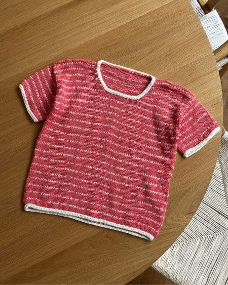 Marie Tee Junior af Tante Grøn. Den er strikket i Marble i fv. 7 Raspberry og Bio Blomsterfrø i fv. 6 Fløde.